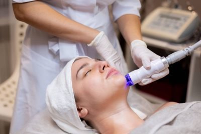 A young beautiful girl lies on the beautician’s table and receives procedures with a professional apparatus for skin rejuvenation and moisturizing A young beautiful girl lies on the beautician's table and receives procedures with a professional apparatus for skin rejuvenation and moisturizing